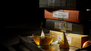 Cutii cadou Tea Forté cu piramide de ceai și cești elegante pe masă